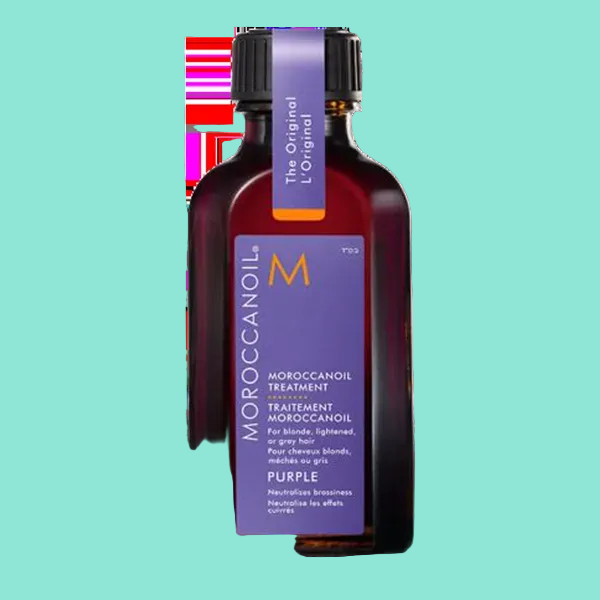 A bottle of MOROCCANOIL VIOLET OIL TREATMENT with a purple label, cap, and a visible hair strand in the foreground.