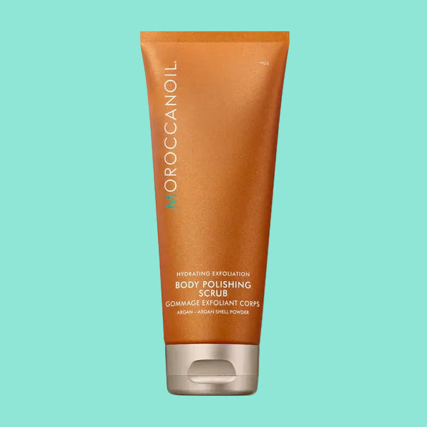A tube of Moroccanoil Body Polishing Scrub, with a shimmering orange and cream color scheme and text detailing the product's benefits and ingredients.