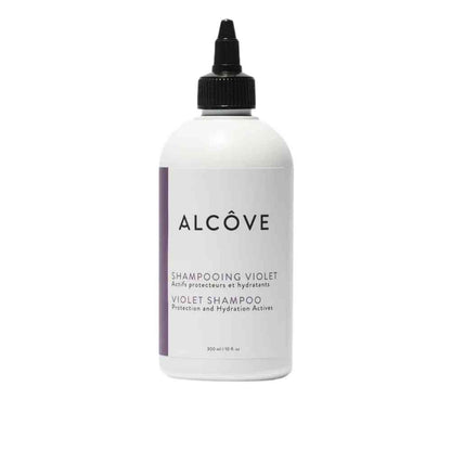 A bottle of Alcôve Violet shampoo with a white label and purple text, focused on eliminating yellow tones and refreshing highlights.