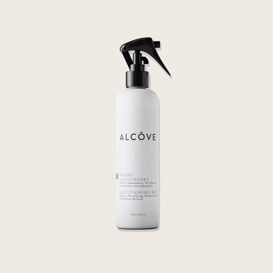 White spray bottle with black nozzle labeled 'Alcove' on a light beige background