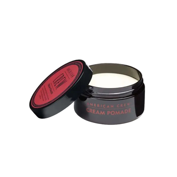 Black jar of American Crew Cream Pomade with red lid on a white background