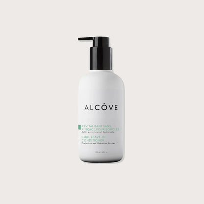 A bottle of Alcôve Curl Leave-In Conditioner with a black pump dispenser and a white bottle,