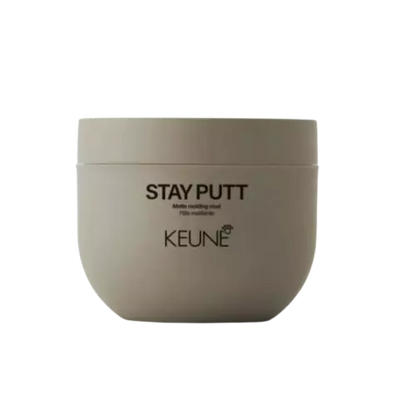 A round beige cosmetic jar labeled 'STAY PUTT' and 'KEUNE' on a plain white background.